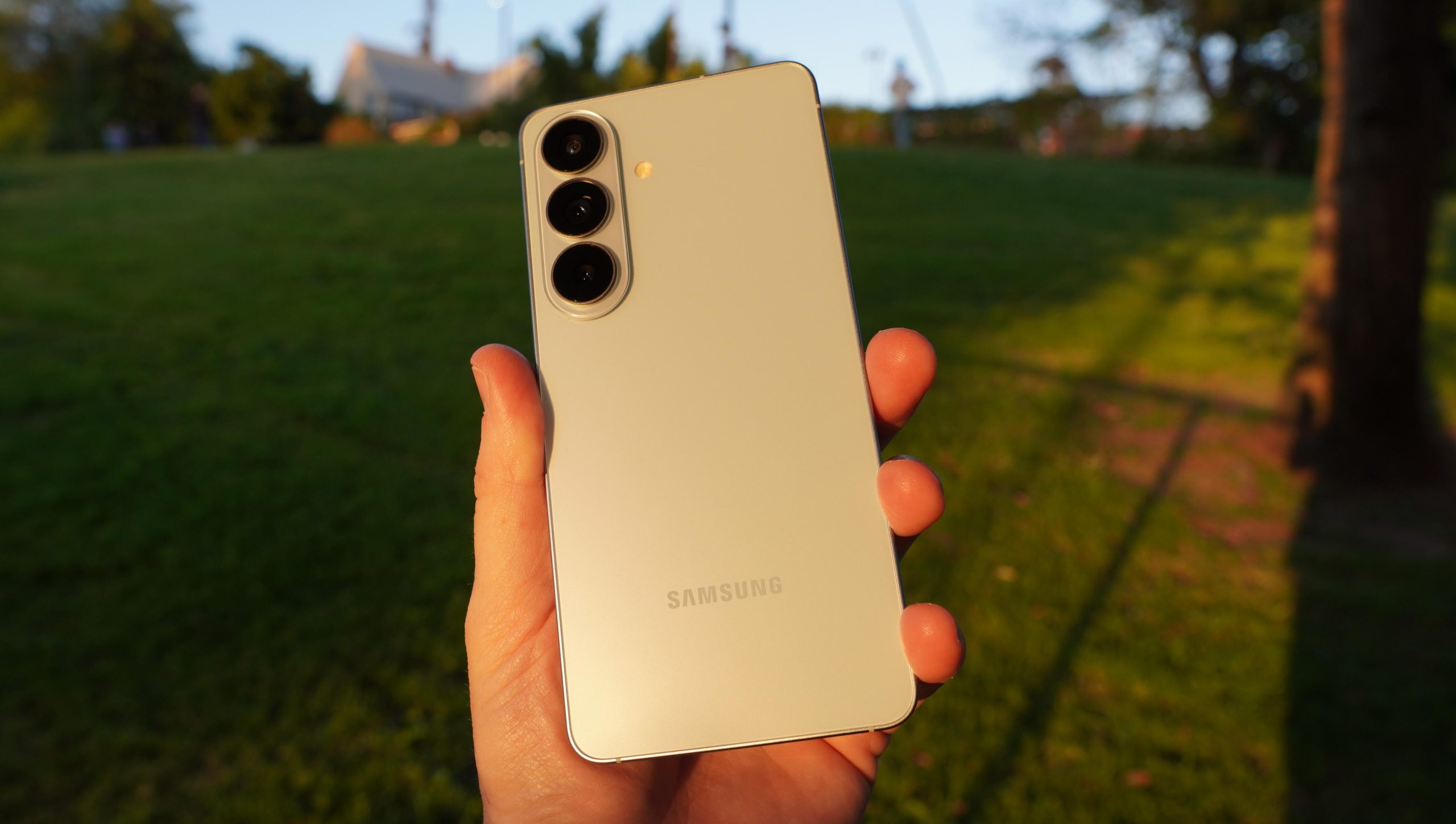 Ljusblå Samsung Galaxy S26 hålls upp i solnedgången